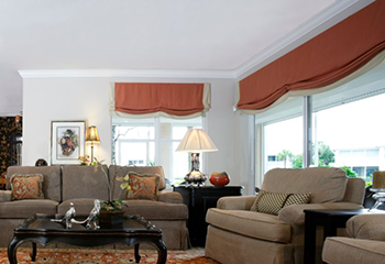 Modern home with orange Roman shades for living area